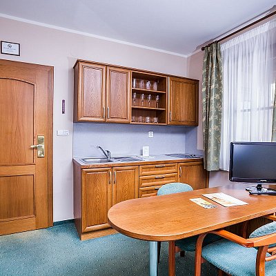 Apartmán hotelu Jelínkova vila - kuchyňka a praktický jídelní stůl s televizí